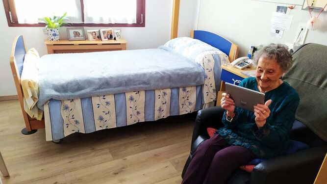 Anciana haciendo una videollamada en una residencia durante la pandemia