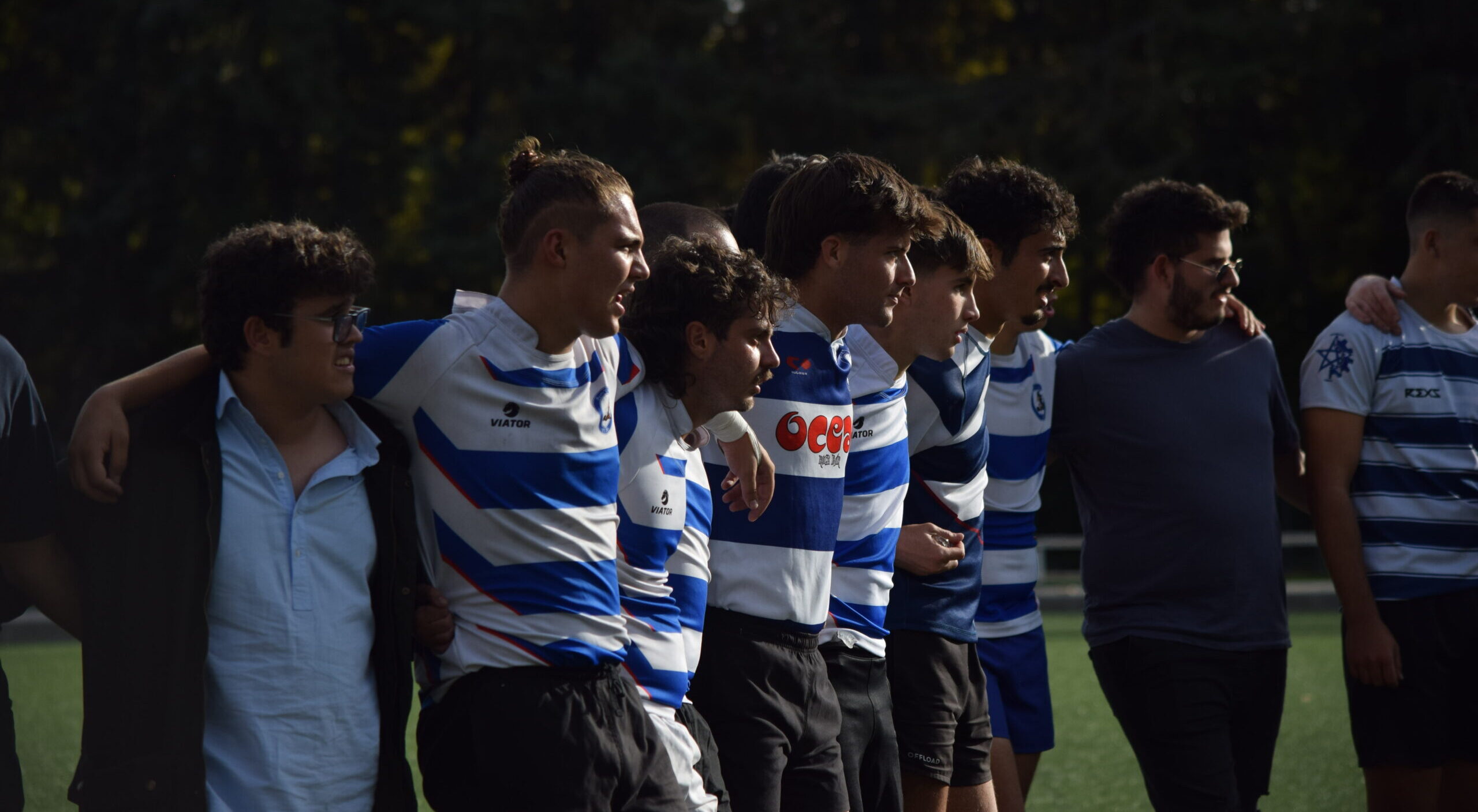 Los jugadores de rugby de la facultad de Ciencias de la Información forman filas para mostrar respeto al rival mientras entonan el himno de su equipo.